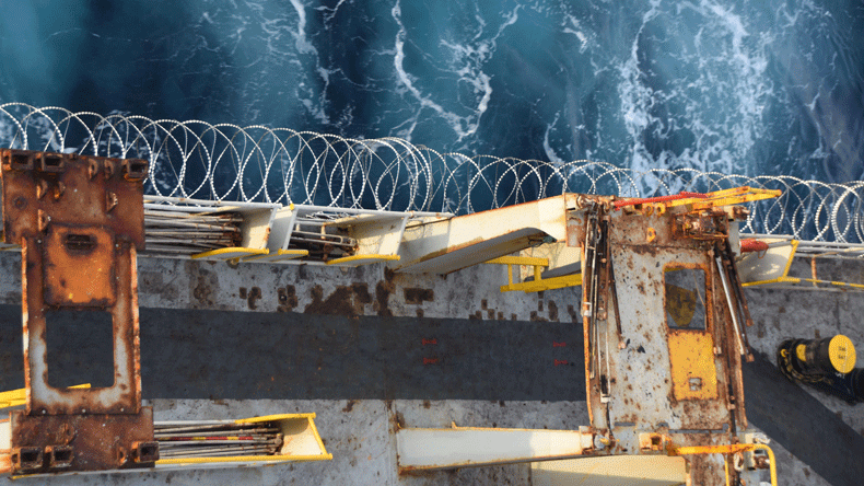 Barbed wire attached to a ship hull, superstructure and railings to protect against piracy attack
