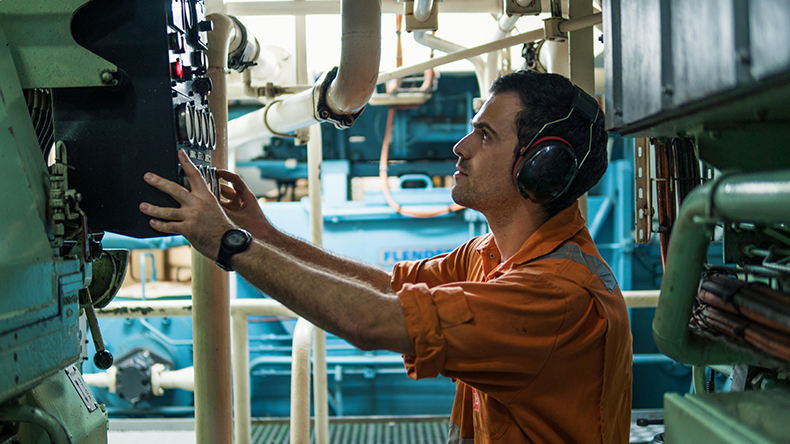 Marine engineer inspecting ship engine