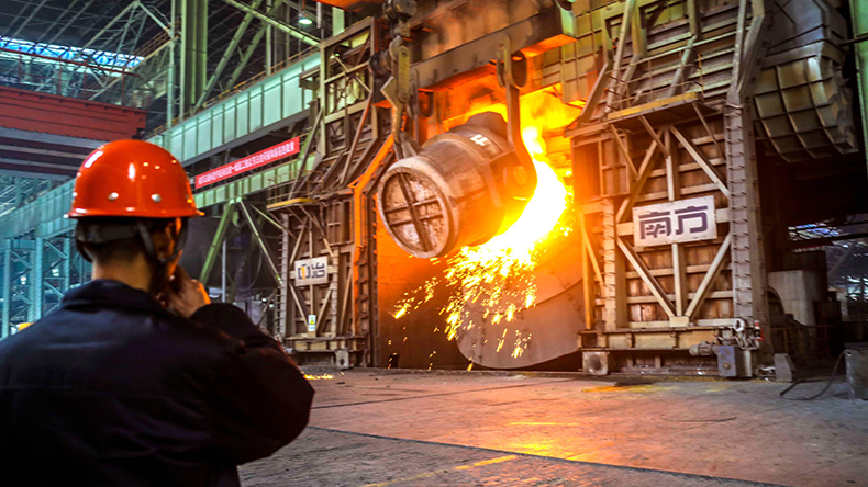A Chinese worker surveys the production of steel in Qingdao city