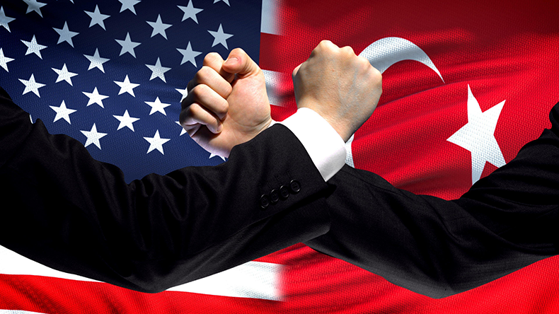  US vs Turkey confrontation, countries disagreement, fists on flag background - Image ID: 2AN1BK2