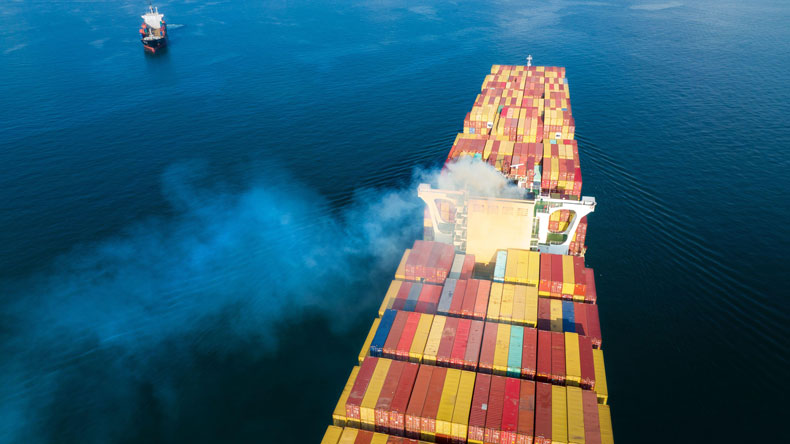 View from stern of boxship shows containers and smoking funnel